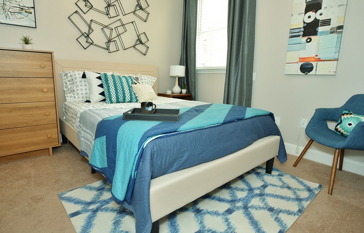 Model bedroom with a dresser and armchair